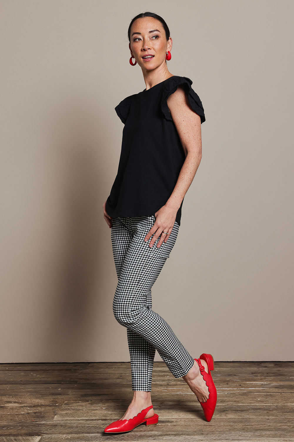 Model Katie wearing size 10 of the Ruffle Sleeve Top in colour Black (Black), from the front, showing the whole outfit
