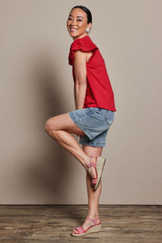 Model Katie wearing size 10 of the Ruffle Sleeve Top in colour Lollipop (Red), from the front, showing the whole outfit