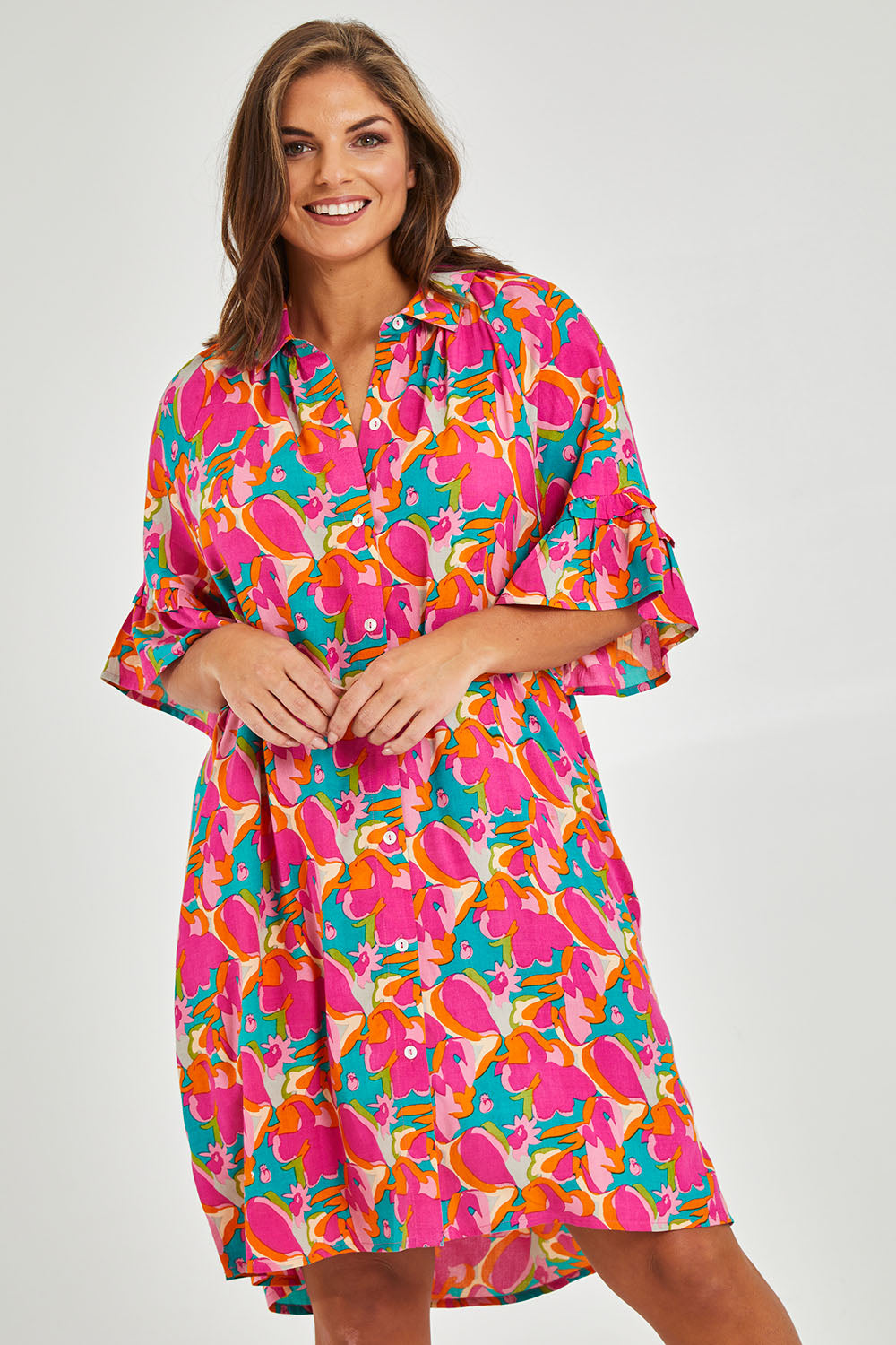 Model Monique wearing size 14 of the Button Through Shirt Dress in colour Boldfloral (Pink), from the front, cropped image