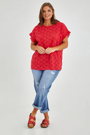 Model Monique wearing size 14 of the Lace Trim Shell Top in colour Lace (Red), from the front, showing the whole outfit