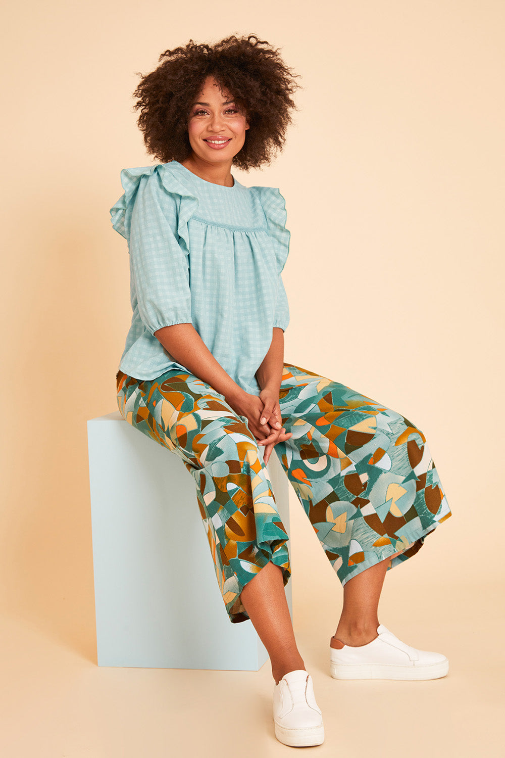 Model Olivia wearing size 10 of the Printed Wide Leg Pant in colour Geometric (Green), from the front, showing the whole outfit