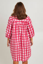Model Monique wearing size 14 of the Printed Waist Detail Dress in colour Berrycheck (Pink), from the back