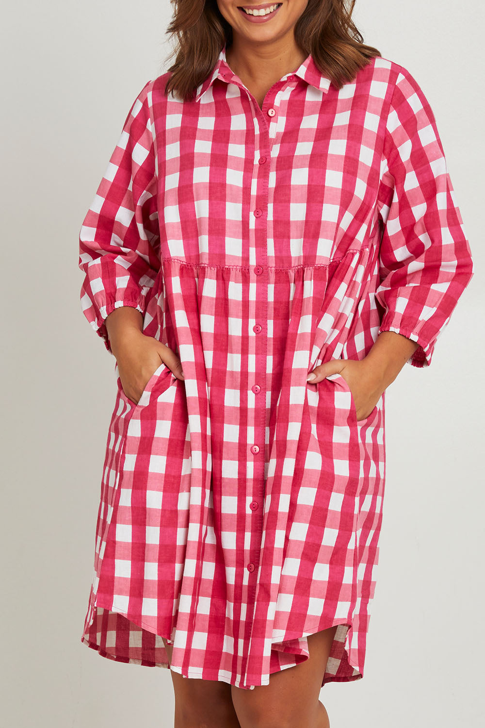 Model Monique wearing size 14 of the Printed Waist Detail Dress in colour Berrycheck (Pink), from the front, cropped image