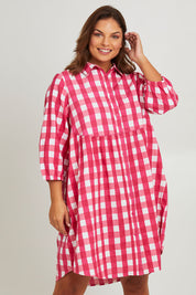 Model Monique wearing size 14 of the Printed Waist Detail Dress in colour Berrycheck (Pink), from the front, cropped image