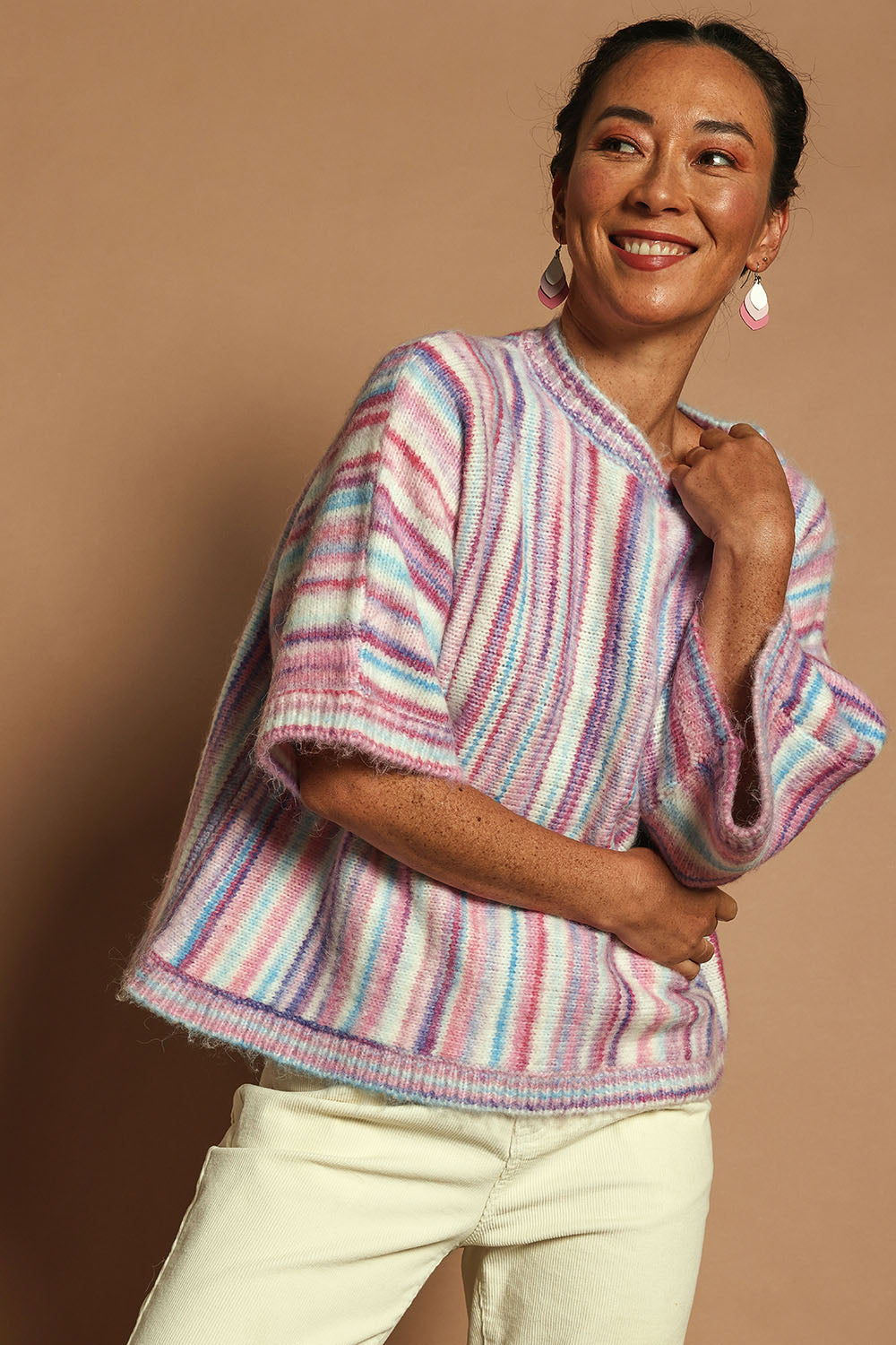 Model Katie wearing size S of the Striped Oversize Sweater in colour Candyfloss (Pink), from the front, cropped image