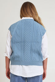 Model Chanel wearing the Cable Vest in colour Bluehaze (Blue), from the back