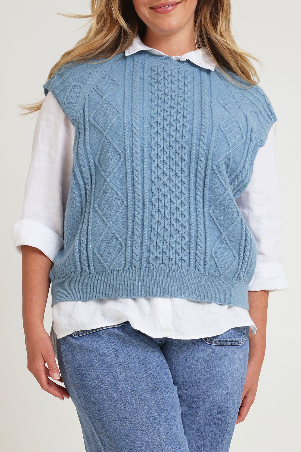 Model Chanel wearing the Cable Vest in colour Bluehaze (Blue), from the front, cropped image