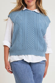 Model Chanel wearing the Cable Vest in colour Bluehaze (Blue), from the front, cropped image