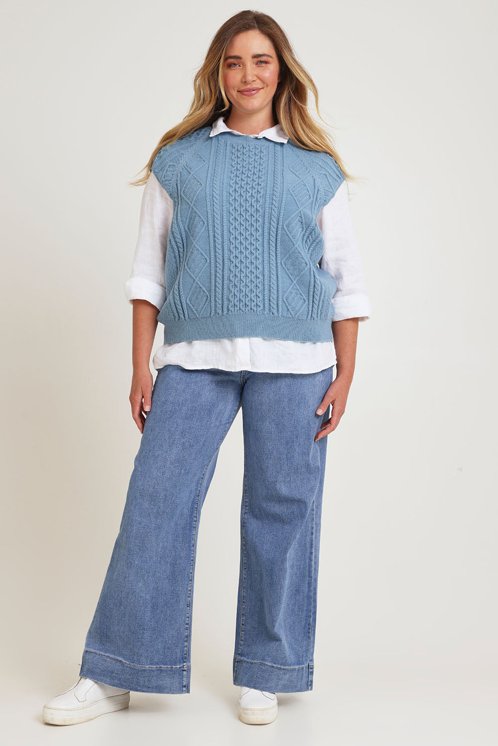 Model Chanel wearing the Cable Vest in colour Bluehaze (Blue), from the front, showing the whole outfit
