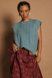 Model Katie wearing the Cable Vest in colour Bluehaze (Blue), from the front, showing the whole outfit