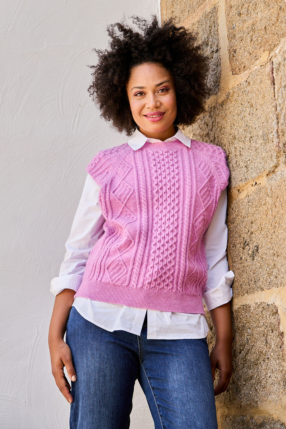 Model Olivia wearing the Cable Vest in colour Cable (Pink), from the front, showing the whole outfit