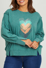 Model Monique wearing size 14 of the Heart Cotton Sweater in colour Hearts (Green), from the front, cropped image