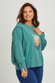 Model Monique wearing size 14 of the Heart Cotton Sweater in colour Hearts (Green), from the front, cropped image