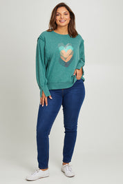 Model Monique wearing size 14 of the Heart Cotton Sweater in colour Hearts (Green), from the front, showing the whole outfit