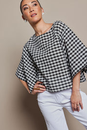 Model Katie wearing size 10 of the Yarn Dyed Cotton Wide Sleeve Top in colour Gingham (Black), from the front, cropped image