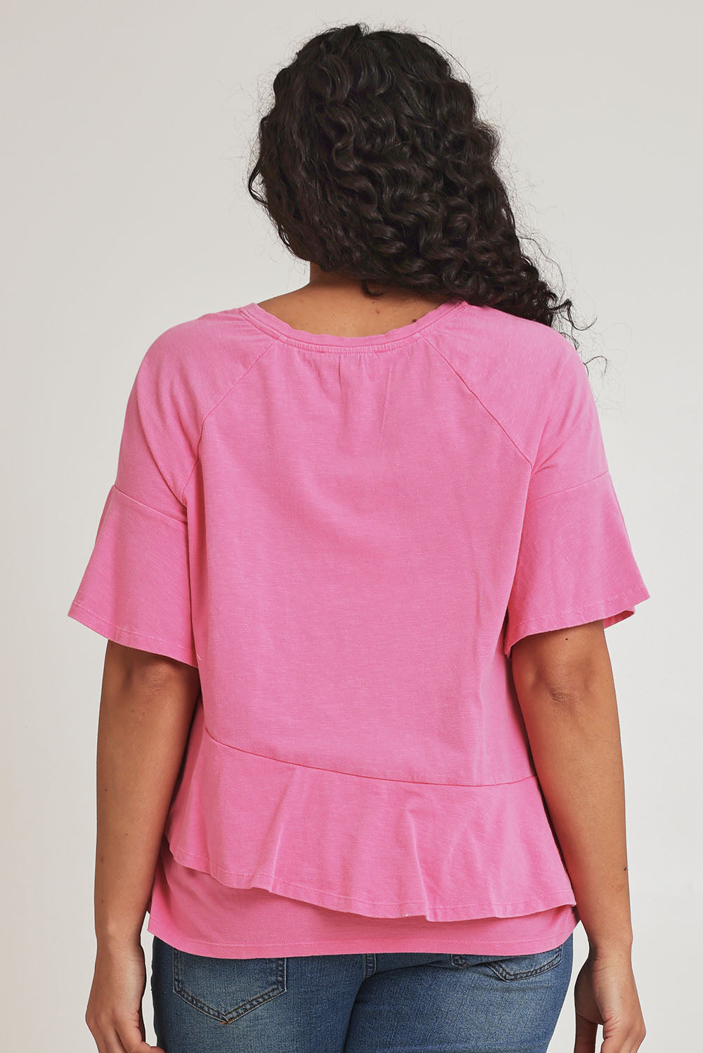 Model Terri-Leigh wearing size 14 of the Asymmetrical Frill Cotton Top in colour Pink (Pink), from the back