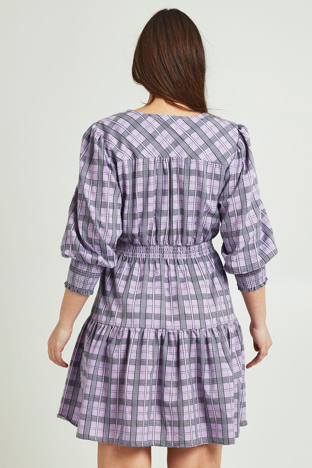 Model Jane wearing size 14 of the Peggy Shirred Waist Cotton Dress in colour Check (Purple), from the back