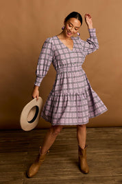 Model Katie wearing size 10 of the Peggy Shirred Waist Cotton Dress in colour Check (Purple), from the front, showing the whole outfit