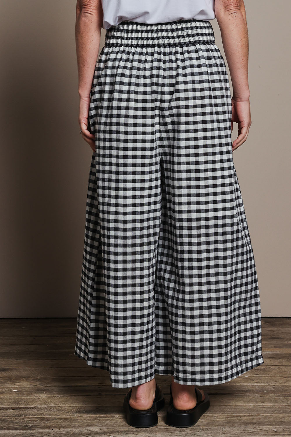 Model Katie wearing size 10 of the Cotton Waist Tie Pants in colour Gingham (Black), from the back