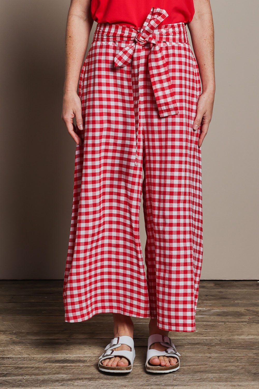 Model Katie wearing size 10 of the Cotton Waist Tie Pants in colour Ginghamred (Red), from the front, cropped image