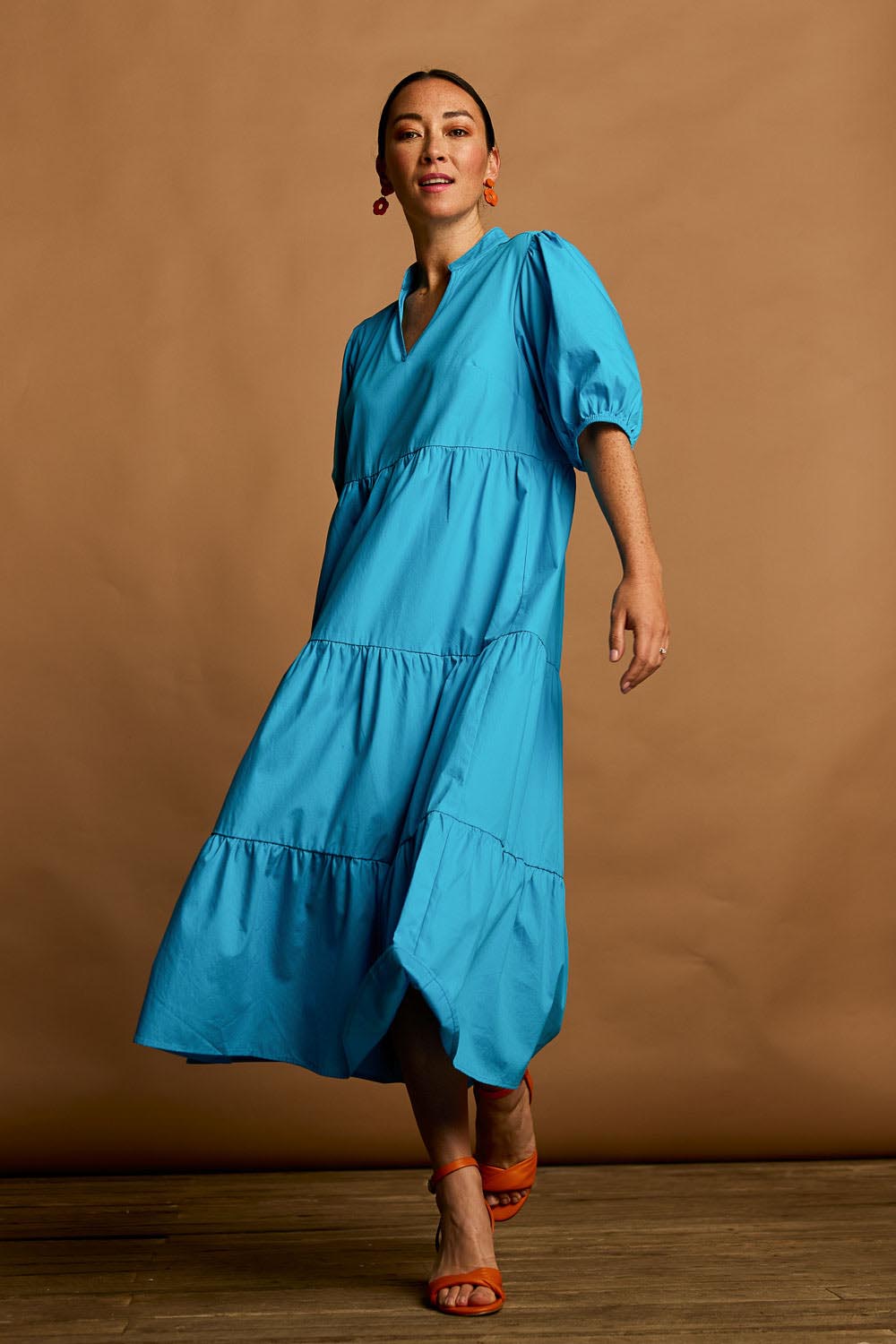 Model Katie wearing size 10 of the Tiered Cotton Dress in colour Jewel (Blue), from the front, showing the whole outfit