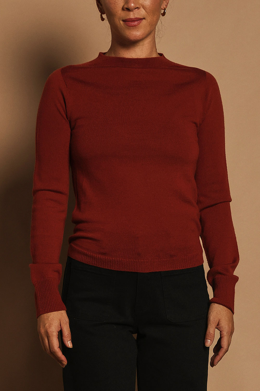 Model Katie wearing size S of the Extra Fine Merino Wool Long Sleeve Knit in colour Rust, from the front, cropped image