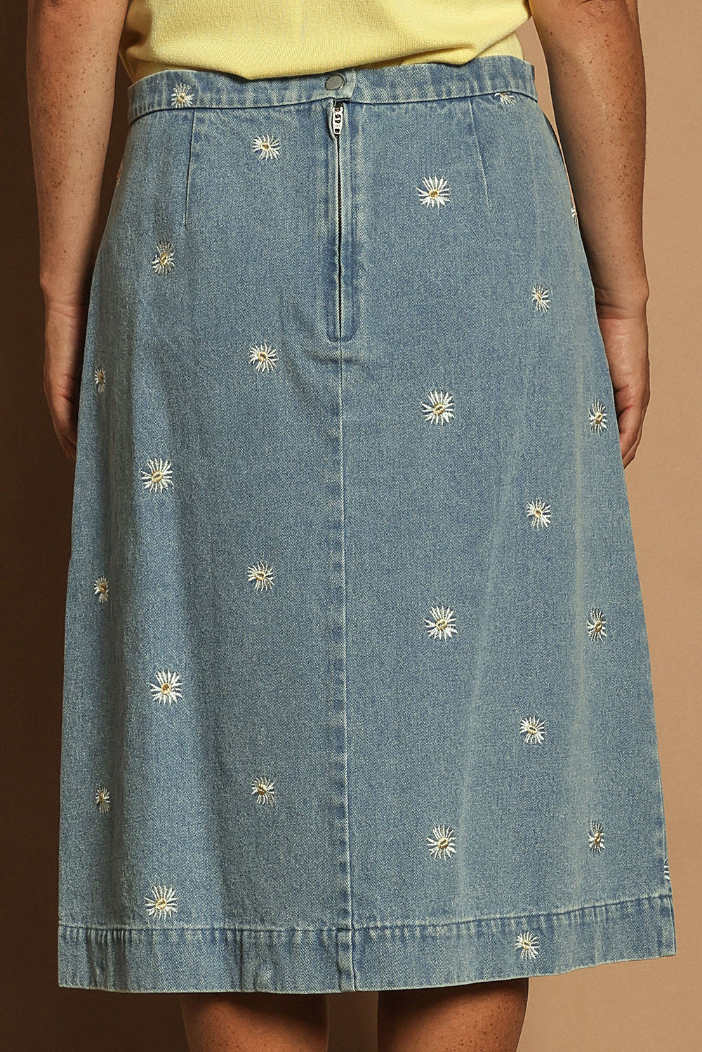 Model Katie wearing size 10 of the Daisy Denim A Line Skirt in colour Daisy (Blue), from the back