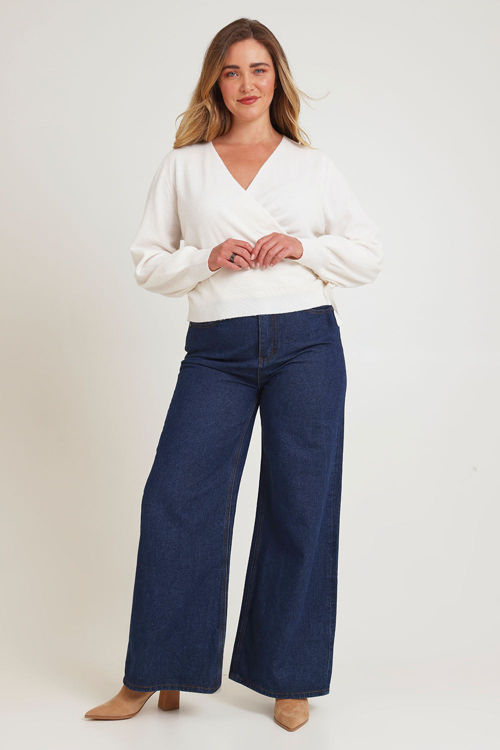 Model Chanel wearing size XL of the Wrap Knit Sweater in colour Cream (White), from the front, showing the whole outfit