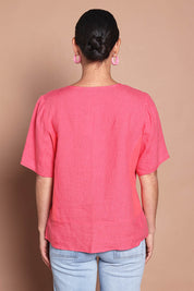 Model Katie wearing size 10 of the Linen Elastane V Neck Blouse in colour Melon (Pink), from the back