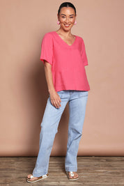 Model Katie wearing size 10 of the Linen Elastane V Neck Blouse in colour Melon (Pink), from the front, showing the whole outfit