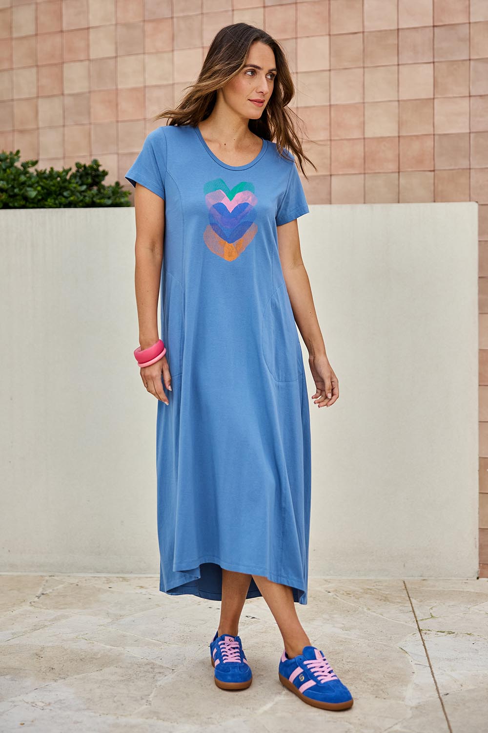 Model Tegand wearing size 10 of the Heart Logo Dress – Bluegreen in colour Bluegreen, from the front