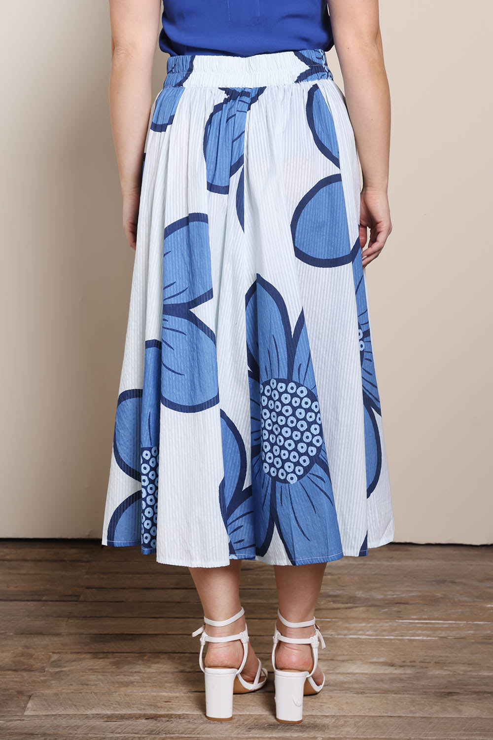 Model Georgiel wearing size 10 of the Cotton Flower Skirt – Blue in colour Blue, from the back
