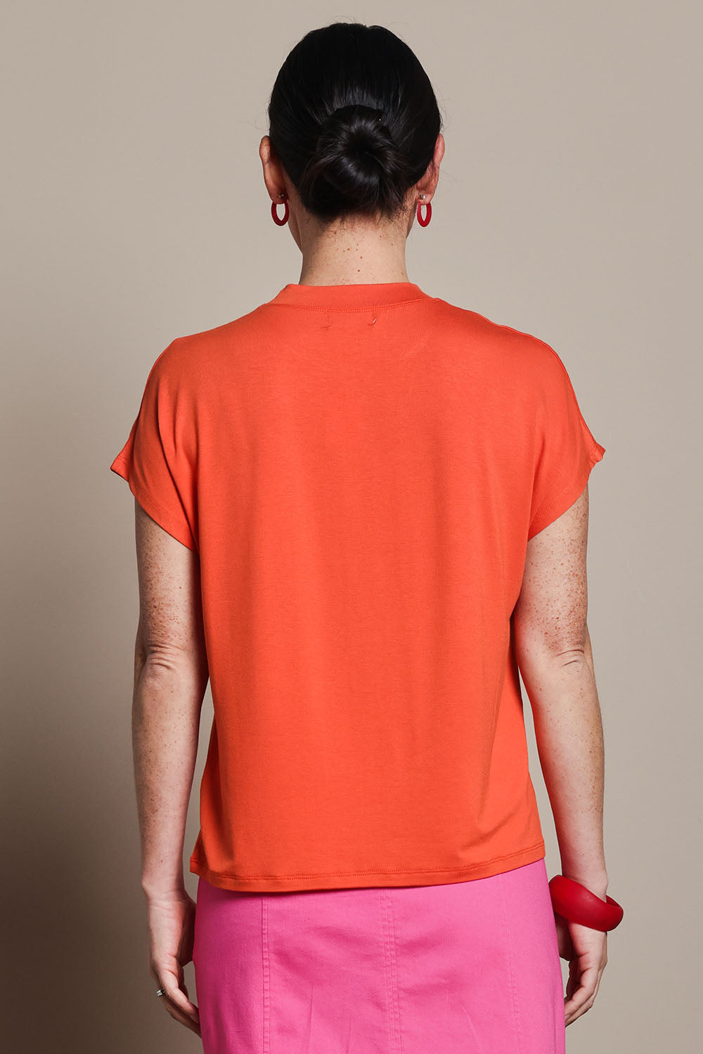 Model Katie wearing size 10 of the Cap Sleeve Tee in colour Tangerine, from the back