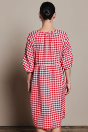 Model Katie wearing size 10 of the Cotton Empire Waist Dress in colour Ginghamred (Red), from the back