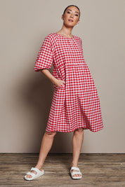 Model Katie wearing size 10 of the Cotton Empire Waist Dress in colour Ginghamred (Red), from the front, showing the whole outfit