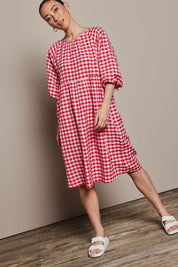 Model Katie wearing size 10 of the Cotton Empire Waist Dress in colour Ginghamred (Red), from the front, showing the whole outfit