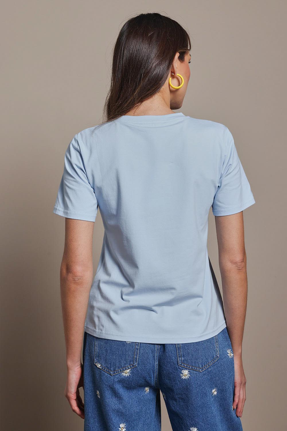 Model Madeline wearing size 10 of the Cotton Daisy Tee in colour Blue (Blue), from the back