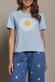Model Madeline wearing size 10 of the Cotton Daisy Tee in colour Blue (Blue), from the front, cropped image
