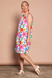 Model Katie wearing size 10 of the Printed Sleeveless Dress in colour Bloompop, from the front, showing the whole outfit