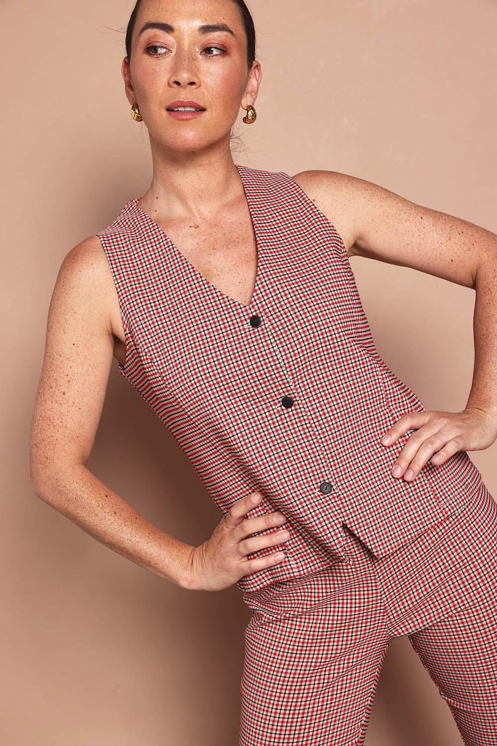Model Katie wearing size 10 of the Stretch Check Vest in colour Redcheck (Red), from the front, cropped image
