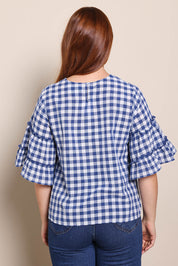 Model Georgiel wearing size 10 of the Cotton Gingham Frill Blouse – Blue in colour Blue, from the back