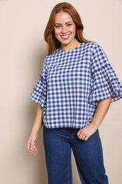 Model Georgiel wearing size 10 of the Cotton Gingham Frill Blouse – Blue in colour Blue, in a cropped view