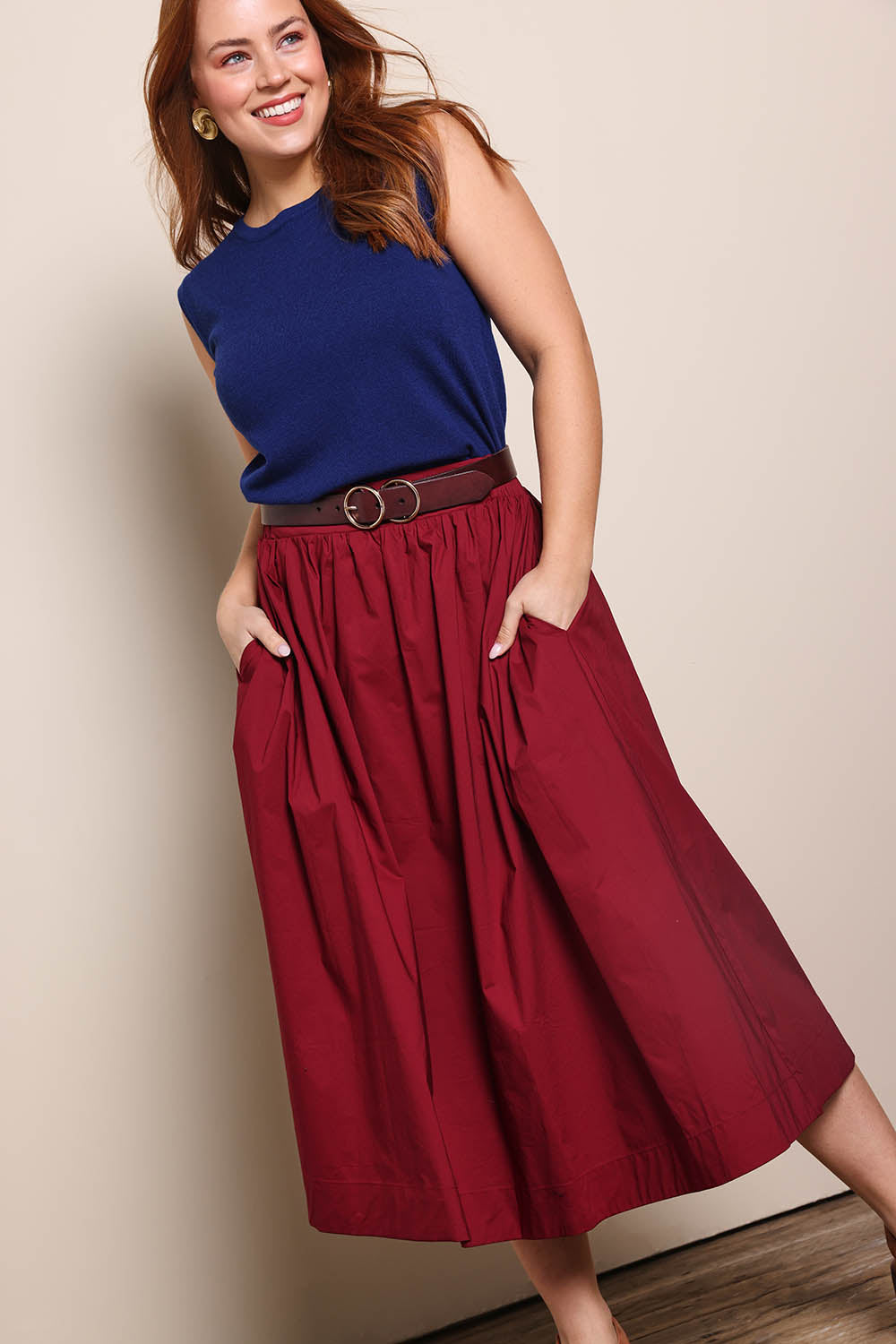 Model Georgiel wearing size 10 of the Cotton Blend Midi Skirt – Burgundy in colour Burgundy, from an angle