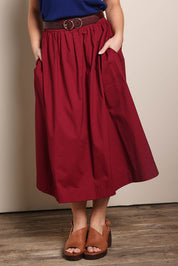 Model Georgiel wearing size 10 of the Cotton Blend Midi Skirt – Burgundy in colour Burgundy, in a cropped view
