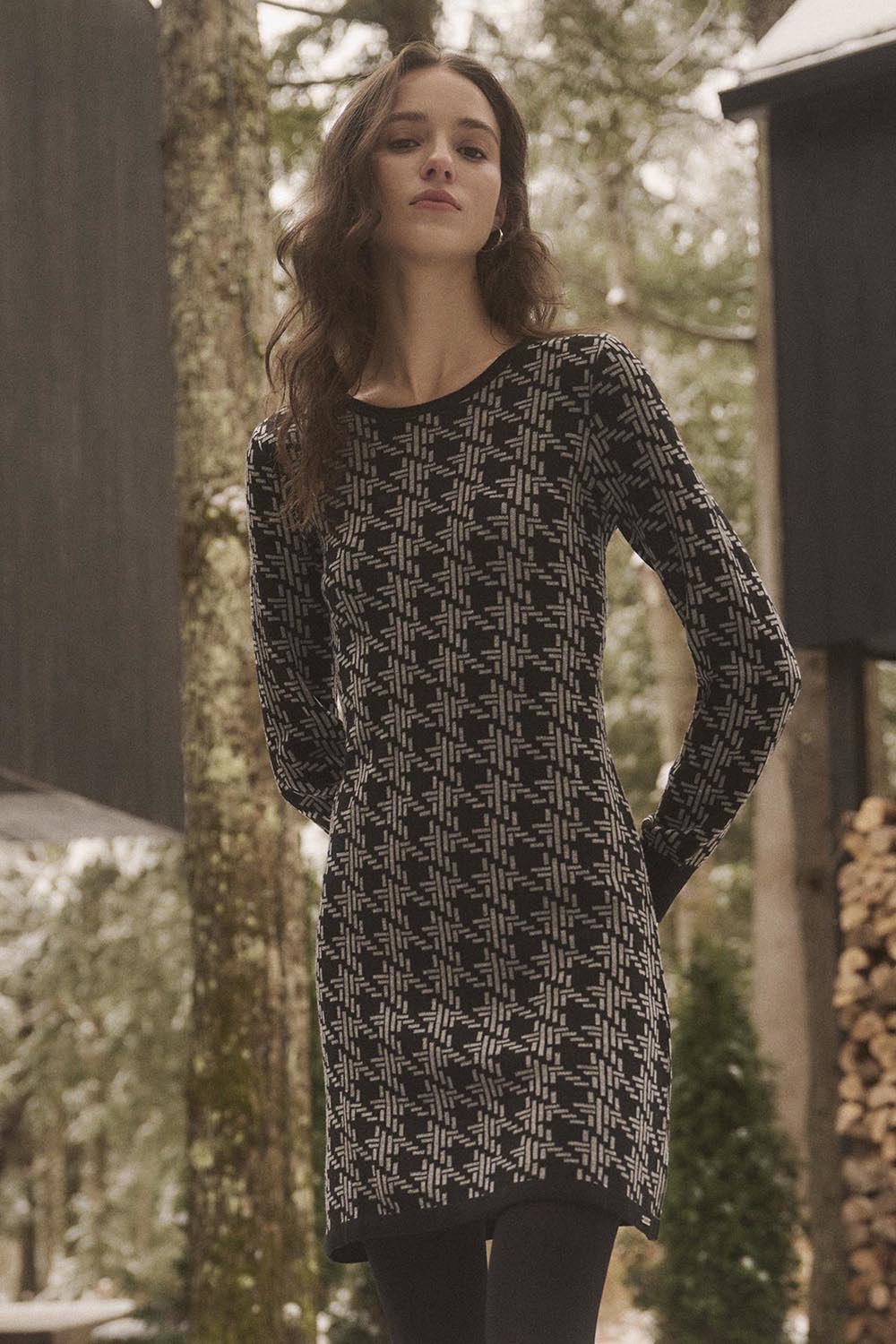 A model wearing the Abigail Sweater Dress in colour Houndstoo (Black), from the front, showing the whole outfit
