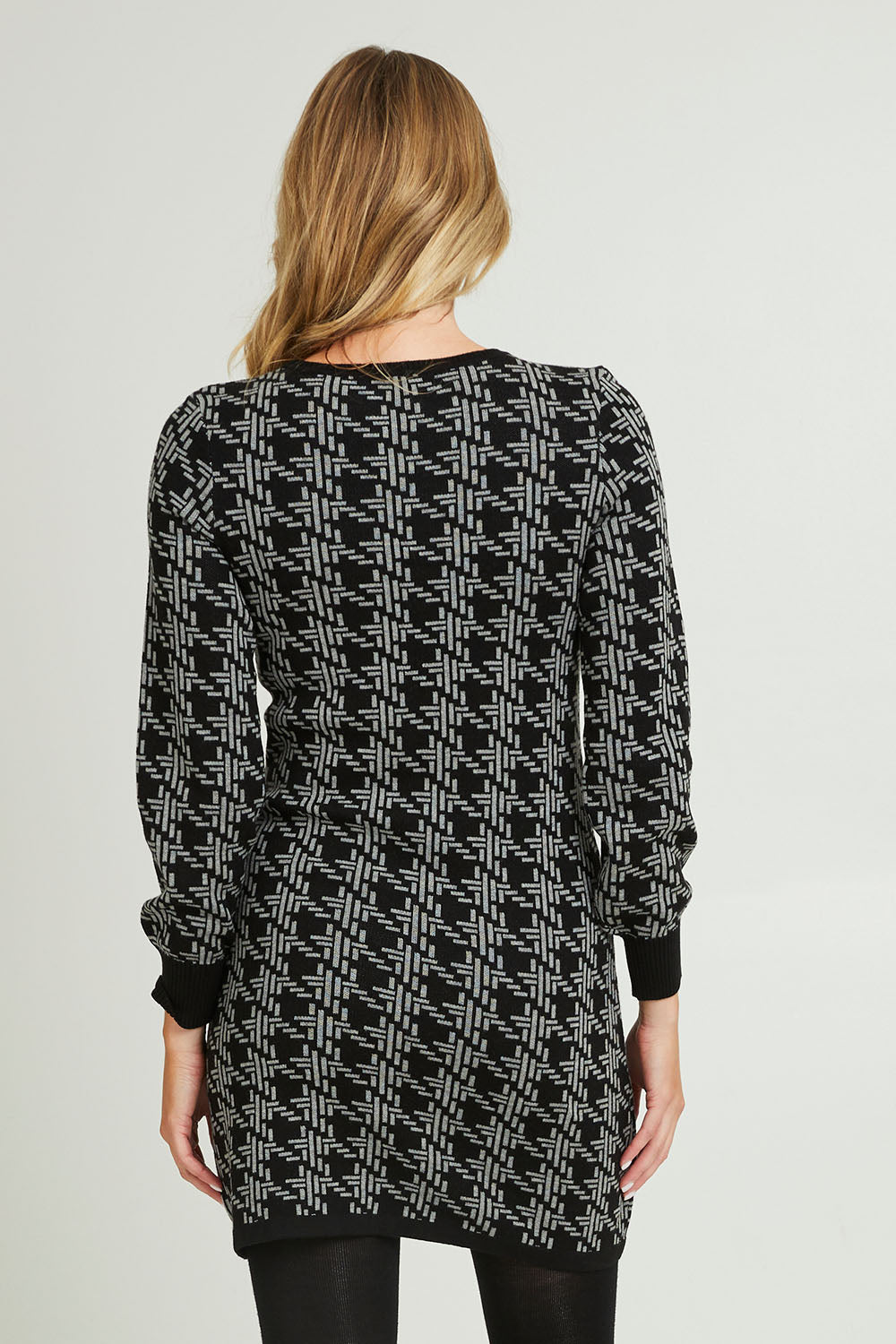Model Grace wearing size S of the Abigail Sweater Dress in colour Houndstoo (Black), from the back