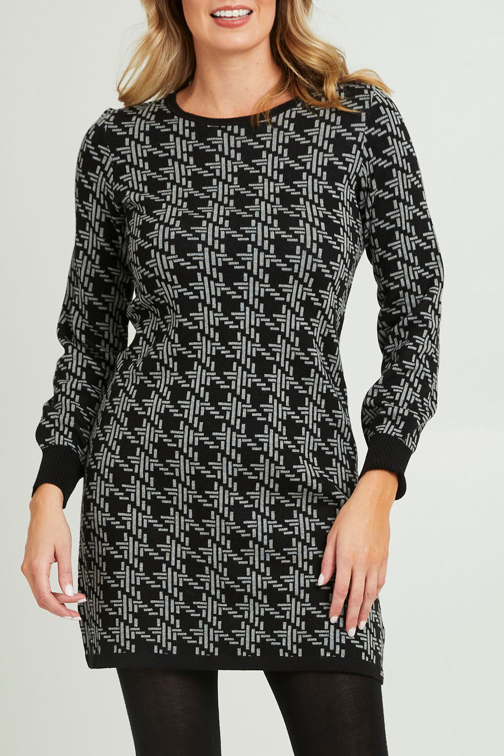 Model Grace wearing size S of the Abigail Sweater Dress in colour Houndstoo (Black), from the front, cropped image