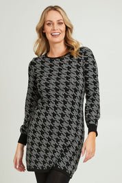 Model Grace wearing size S of the Abigail Sweater Dress in colour Houndstoo (Black), from the front, cropped image