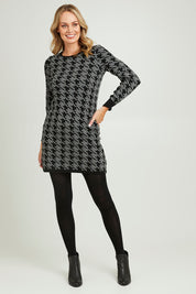 Model Grace wearing size S of the Abigail Sweater Dress in colour Houndstoo (Black), from the front, showing the whole outfit