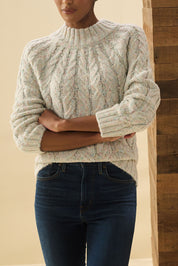 A model wearing the Dylan Cable Knit Sweater in colour Rainbow, from the front, cropped image